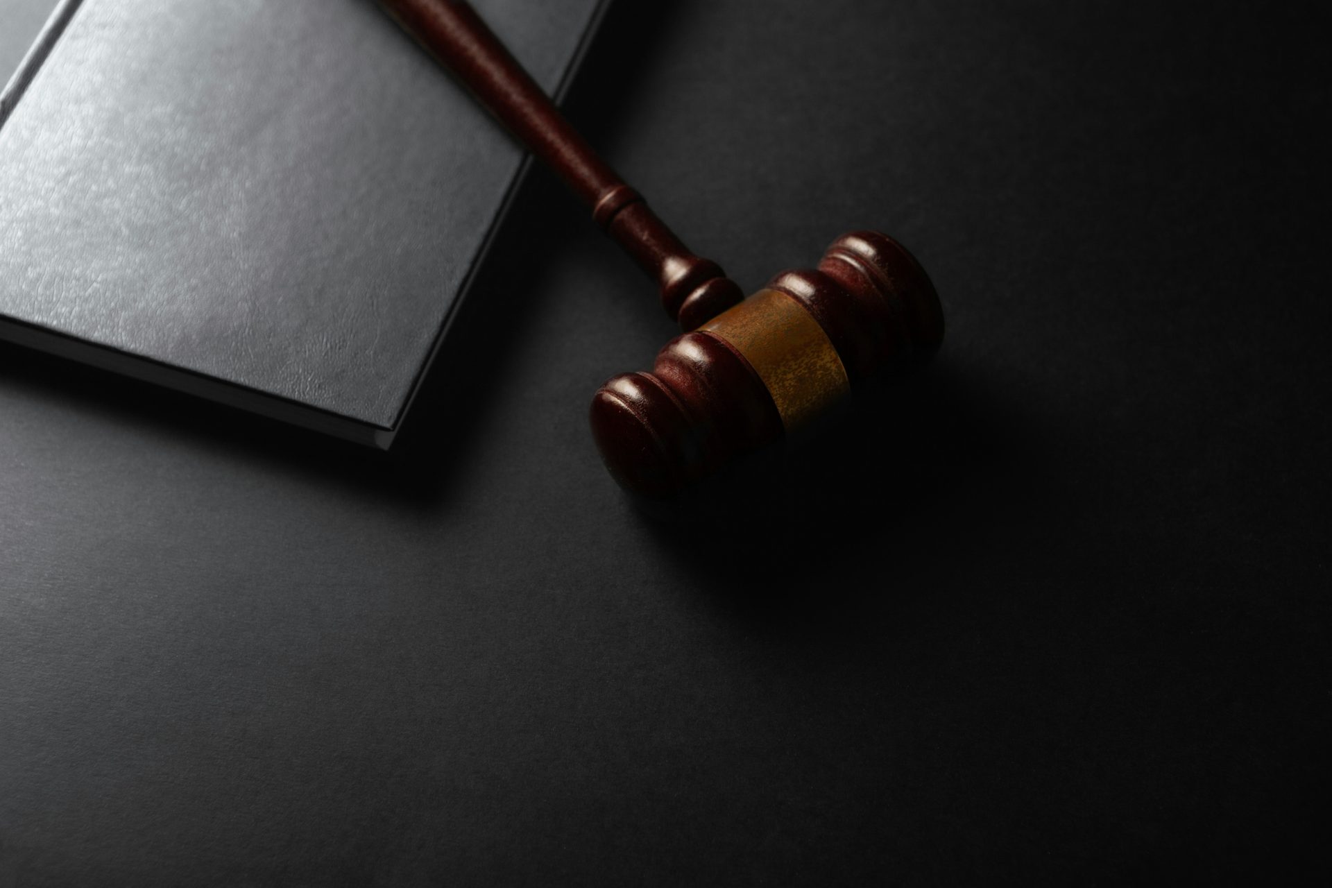 Maillet en bois posé sur une surface sombre à côté d'un livre